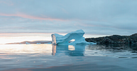 Wall Mural - Arctic nature landscape with icebergs in Antarctica with midnight sun sunset sunrise in the horizon. Summer Midnight Sun and icebergs. Big blue ice in icefjord. Climate change global warming. 