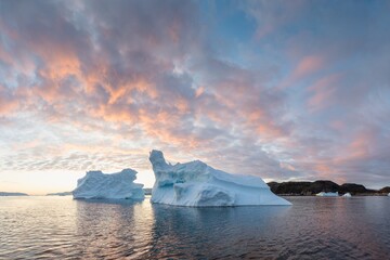 Wall Mural - Arctic nature landscape with icebergs in Greenland icefjord with midnight sun. Early morning summer alpenglow during midnight season. Hidden Danger and Global Warming Concept. Tip of the iceberg.