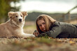 A young woman and her border collie puppy dog cuddling and interacting together in autumn outdoors, dog and owner concept