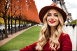 Holidays in Paris. Portrait of charming blonde girl in red sweater and hat visiting Paris, France. European landmark tour. 