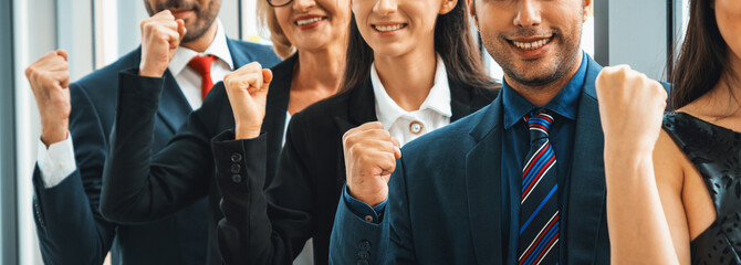 Wall Mural - Successful business people standing together showing strong relationship of worker community. A team of businessman and businesswoman expressing a strong group teamwork at the modern office. Jivy