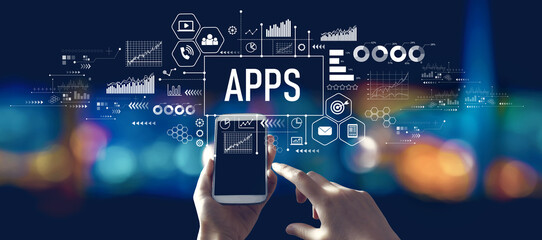 Apps theme with person using a smartphone in a city at night