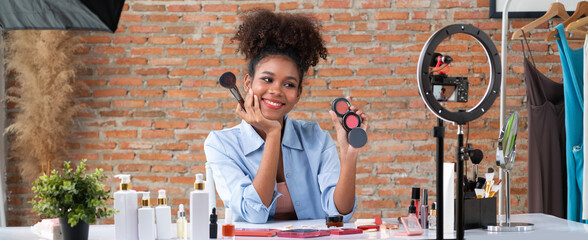 Wall Mural - Woman influencer shoot live streaming vlog video review makeup crucial social media or blog. Happy young girl with cosmetics studio lighting for marketing recording session broadcasting online.