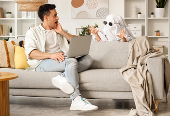 Sticker - Cute little girl in ghost costume scaring her dad at home