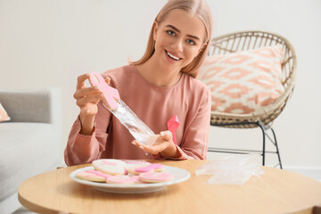 Wall Mural - Young woman bagging cookies at home. Breast cancer awareness concept