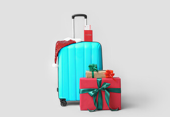 Wall Mural - Suitcase, passport, Santa hat and Christmas gifts on color background