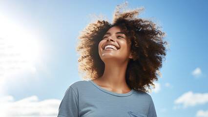 Wall Mural - A African woman breathes calmly looking up isolated on clear blue sky