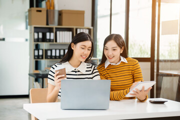 Sticker - Two Asian businesswoman discuss investment project working and planning strategy with tablet laptop computer 