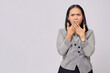 © Bangun Stock Photo - Surprised beautiful young Asian woman in casual clothes covering mouth with hand, looking at the camera with amazed facial expression isolated on white background. People lifestyle concept