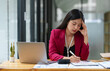 © Phimwilai - tired business woman sleepy and bored from sitting at a desk for a long time and has office syndrome