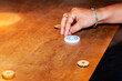 A young boy playing carom board under light, selective focus.