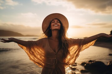 Wall Mural - An image of a young, pretty woman standing at the water's edge on a sun-kissed beach, her arms outstretched as she embraces the liberating feeling of the ocean breeze