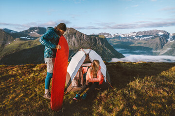 Wall Mural - Couple friends setting up tent camping gear travel in mountains, man inflating sleeping pad, active vacations outdoor adventures man and woman hiking together family tour healthy lifestyle in Norway