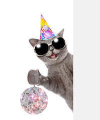 Aufkleber - Happy cat wearing sunglasses and party cap looks from behind empty banner and shows dico ball. isolated on white background