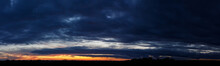 Panoramic Sunset Sky With Heavy Dark Blue Clouds And Orange Line Of Sun