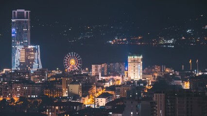 Canvas Print - Batumi, Adjara, Georgia. 4k Elevated View Ferris Wheel At Promenade In Miracle Park, Amusement City Park. Night Lighting Timelapse Elevated View Evening Skyscraper Batumi. Night City Life. Timelapse