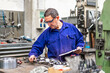 © unai - Factory worker operator in the numerical control sector making a report, industrial factory