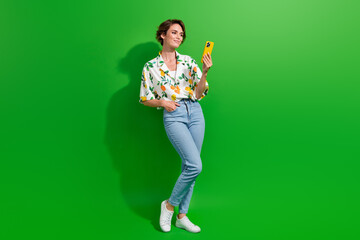 Poster - Full length body photo of attractive young lady using smartphone texting boyfriend wear stylish outfit isolated on green color background