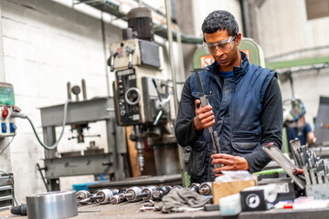 Latino worker in the metal industrial factory trade in the numerical control sector