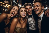 Fototapeta  - A company of happy young people in evening dresses and suits, smiling posing for camera. Party, graduation for students. Celebrating the new year.