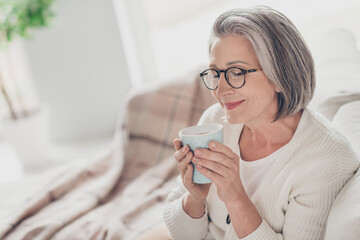 Sticker - Photo of smiling dreamy elderly lady wear white cardigan enjoying fresh cacao aroma indoors apartment room