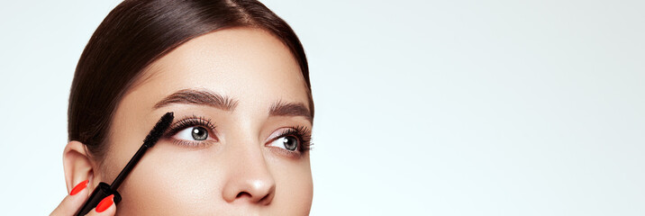 Wall Mural - beauty woman applying black mascara on eyelashes with makeup brush. eyelash extensions. makeup, cosm