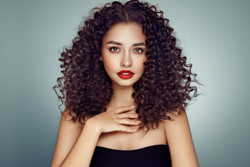 Wall Mural - fashion studio portrait of beautiful smiling woman with afro curls hairstyle. fashion and beauty