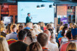 © Anton Gvozdikov - Back view of multiethnic business professionals listening to speaker giving presentation in conference hall