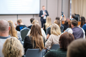 Wall Mural - back view of businesswoman attending presentation with diverse participants in conference hall
