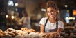 Portrait of a beautiful young woman in apron standing at counter in bakery
