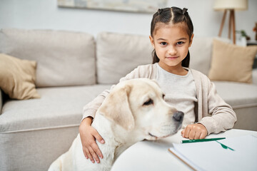 Wall Mural - happy girl in casual clothes drawing and hugging labrador in modern living room, art and leisure