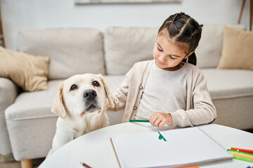 Wall Mural - little girl in casual clothes drawing with color pencil and cuddling labrador in living room, art