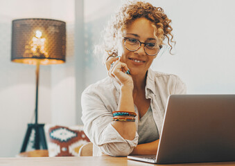 Modern business freelance woman work on laptop at home on the table. Alternative house workplace office and online female people enjoying smart working with computer and internet connection. Business