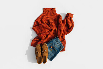 Wall Mural - Fashion autumnal outfit. Knitted brown sweater with loafers and pants or jeans. Women's warm jumper, stylish autumn or winter clothes. Cozy fall look. Flat lay, top view, overhead.