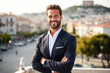 Wealthy attractive happy young male executive smiling looking away posing in downtown athen.