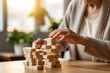 Faceless elderly woman with dementia playing with wooden blocks in geriatric clinic or nursing home close-up