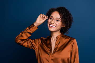 Photo of smart clever woman dressed brown silk shirt arm eyewear smiling isolated blue color background