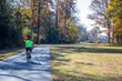 Solo bicylist riding through an autumn wooded scene