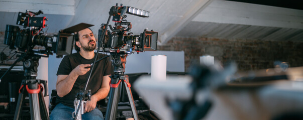 Wall Mural - Director of photography with a camera in his hands on the set. Professional videographer at work on filming a movie