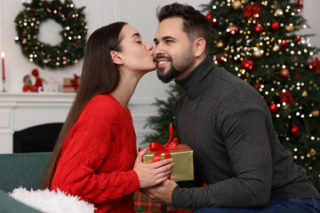 Canvas Print - Beautiful young woman thanking her boyfriend for Christmas gift at home