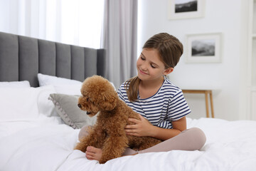 Sticker - Little child with cute puppy on bed at home. Lovely pet