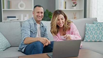 Canvas Print - Man and woman couple having video call sitting on sofa at home