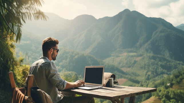 A freelance using laptop in nature with beautiful mountain view, concept of digital nomad working on the go concept.