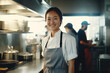 Business portrait of a professional chef, standing in the kitchen and smiling at the camera