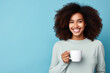 Happy African American woman with cup of coffee on blue background
