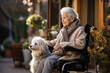 Lonely senior woman in a wheelchair with dog in nursing home looking out the window