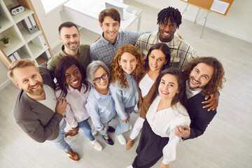 Business team. Overhead view of smiling multiracial male and female colleagues and company employees. Team of Caucasian and African American business people looking up and smiling at camera.