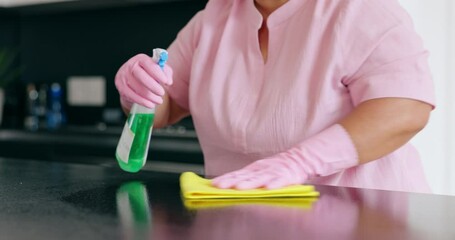 Wall Mural - Woman, cloth and spray for cleaning of kitchen to wipe dust, dirt or bacteria on table for hygiene. Person, hand or housekeeping for disinfectant, detergent or sanitizer with rubber gloves in closeup