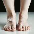 High-resolution image showcasing bare human feet with a clear complexion, standing on a dark surface.