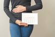 Menstruation, periods cycle day of monthly, hurt young woman, female hand holding, marking symbol on calendar for missed and delay or late. Medical, healthcare, gynecological concept, copy space.
